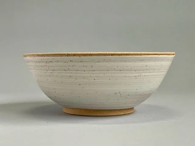 A bowl with a yellow rim and white background