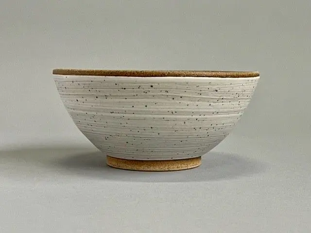 A bowl with white and brown speckles on it.