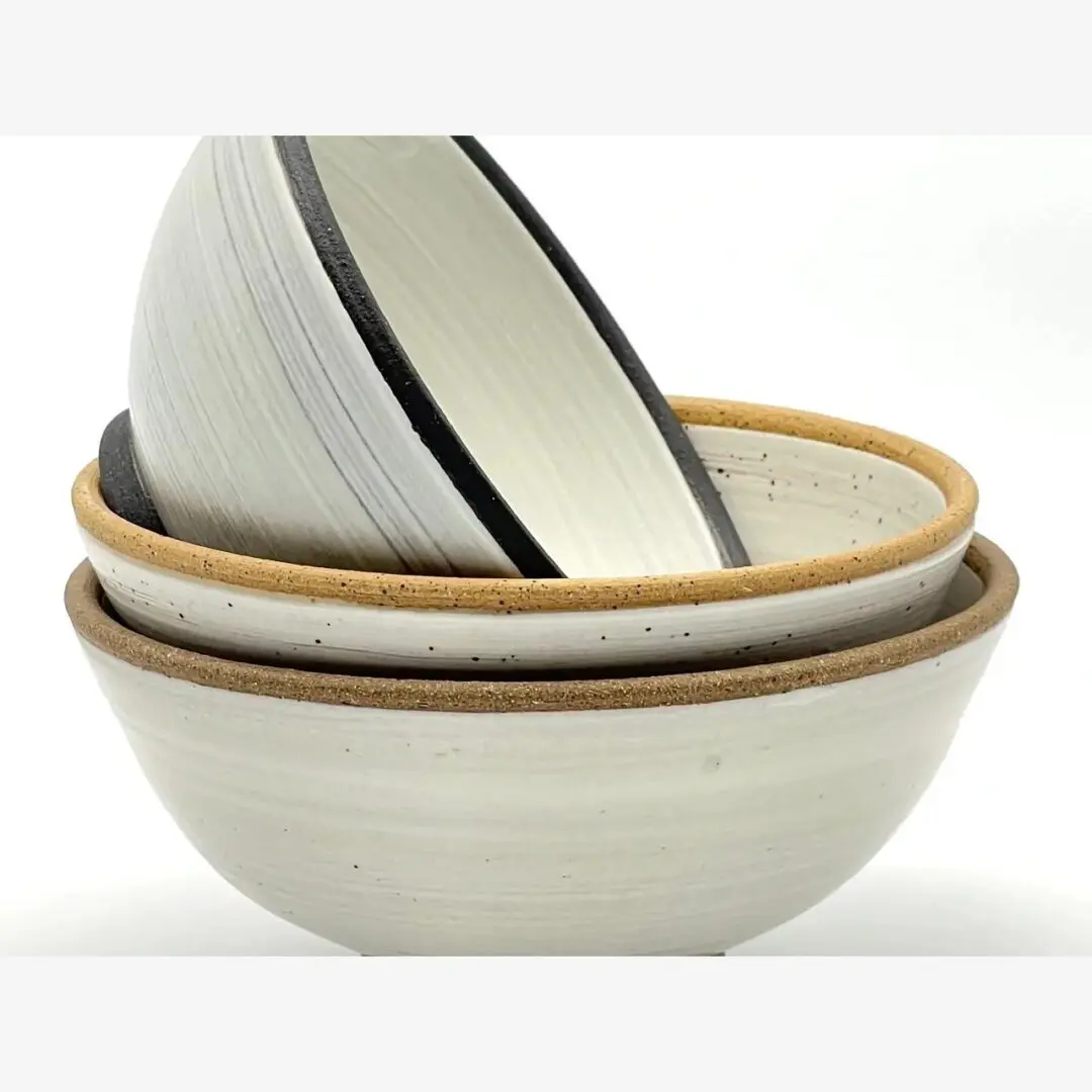 A stack of three bowls with different designs on them.