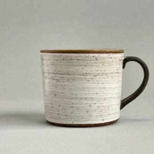 A white cup with brown rim and handle