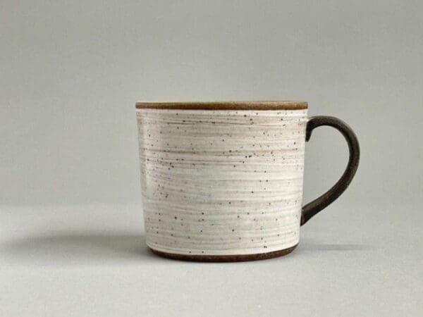 A white cup with brown rim and handle