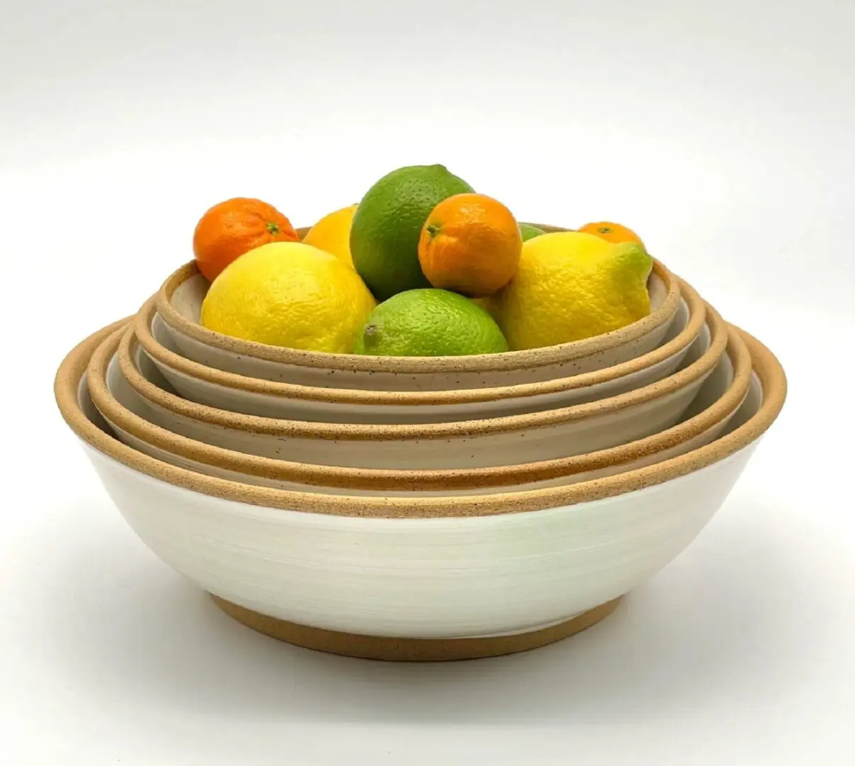 A bowl of fruit is sitting in the middle of four bowls.